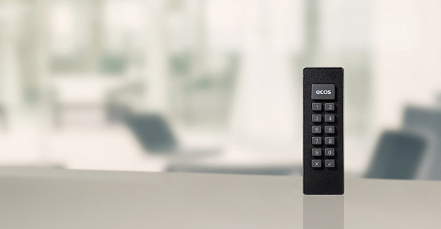 Person arbeitet mit aufgeklapptem Laptop vor sich, Secure Boot Stick SX ist auf dem Tisch platziert