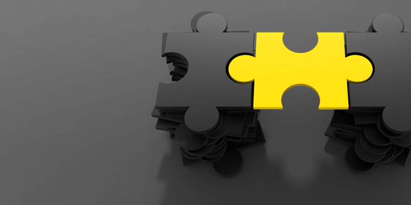 Zwei dunkle Puzzlestücke, die mit einem gelben Puzzlestück verbunden sind. 