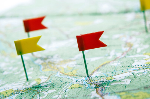 Kleine Flaggen auf Landkarte gepinnt.